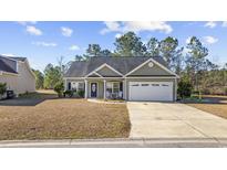 Charming single-story home features a well-manicured lawn, two-car garage and inviting front porch at 825 Payne Ct., Conway, SC 29526
