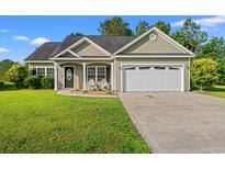 Charming single-story home featuring a manicured front lawn, two-car garage, and rocking chairs on the front porch at 825 Payne Ct., Conway, SC 29526