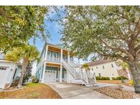 Inviting two-story home with double garage, covered porch, and grand staircase entry, framed by mature trees at 949 Crystal Water Way, Myrtle Beach, SC 29579