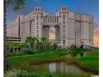 Stunning exterior view of oceanfront building with lush green landscape and beautiful water features at 100 North Beach Blvd. # 1702, North Myrtle Beach, SC 29582