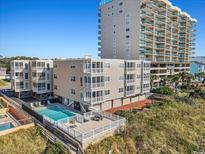 Beautiful tan multi-story condo building featuring a community pool and beach access at 1011 S Ocean Blvd. # 201, North Myrtle Beach, SC 29582