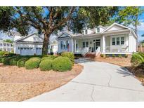 Charming home featuring a well-manicured lawn, a circular driveway, and a spacious front porch for relaxing at 179 Cottage Ct., Pawleys Island, SC 29585