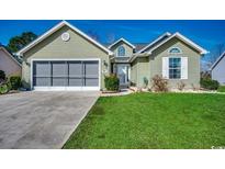 Charming single-story home with a well-manicured lawn, a screened garage, and a welcoming entrance at 179 Heath Dr., Longs, SC 29568