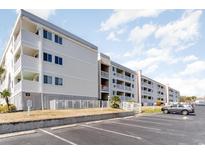 Exterior view of multi-story condo building with on-site parking and multiple balconies at 191 Maison Dr. # B 213, Myrtle Beach, SC 29572