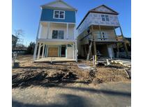 Two-story elevated beach home exterior with blue accents and construction still in progress at 2304 Seaseeker Ln., Myrtle Beach, SC 29579