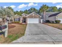 Charming brick home with a two-car garage and well-manicured landscaping on a sunny day at 2454 N Windmill Way, Myrtle Beach, SC 29579