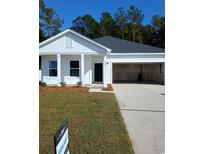 Charming single-story home featuring a black front door, attached garage, manicured lawn, and tasteful landscaping at 3065 Palma Way, Myrtle Beach, SC 29579