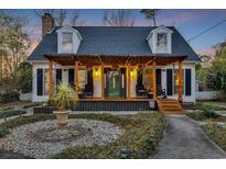 Charming home featuring a pergola covered front porch, dormer windows, and beautifully landscaped yard at 4405 Boxwood St., Myrtle Beach, SC 29577