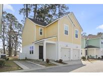 Two story home with a yellow exterior, white trim, and a two-car garage at 4718 Cloisters Ln., Myrtle Beach, SC 29577