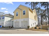 Charming yellow home featuring two-car garage and white trim at 4718 Cloisters Ln., Myrtle Beach, SC 29577