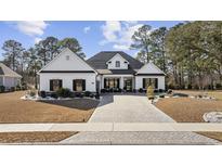 Beautiful single-story home with a manicured lawn and a brick paver driveway at 1109 Wigeon Dr., Conway, SC 29526