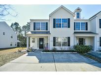 Charming townhome with a well-maintained lawn and inviting entrance with black shutters and a concrete driveway at 1144 Harvest Circle # 1144, Myrtle Beach, SC 29579