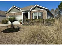 Charming brick home featuring a well-manicured lawn, a one car garage, and stylish shutters at 156 Legends Village Loop, Myrtle Beach, SC 29579