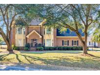 Charming two-story brick home with a well-manicured lawn and mature shade trees at 268 Wraggs Ferry Rd., Georgetown, SC 29440