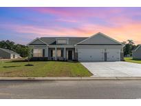 Charming one-story home with a spacious two-car garage, well-manicured lawn, and lovely curb appeal at 439 Lifestyle Court, Surfside Beach, SC 29575