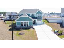 Charming two-story home with blue siding, stone accents, manicured lawn, and a pristine driveway at 511 Rose Fountain Dr., Myrtle Beach, SC 29579