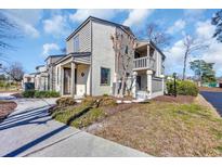 Two-story townhouse with neutral siding, a small balcony, a gated front patio, and a well-manicured front yard at 610 15Th Ave. S # 1, Surfside Beach, SC 29575