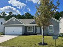 Charming single-story home featuring manicured lawn and a two-car garage, new construction at 1239 Cypress Shoal Dr., Conway, SC 29526