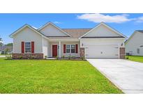 Charming single-story home featuring a well-manicured lawn and a two-car garage at 124 Old Chimney Ln, Conway, SC 29526