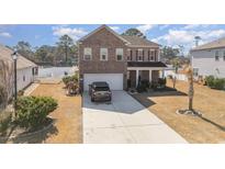 Charming two-story brick home featuring a spacious driveway and attached two-car garage at 160 Ocean Commons Dr., Surfside Beach, SC 29575