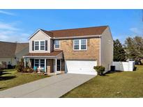 Charming two-story home features brick and siding, a well-manicured lawn, and a two-car garage at 182 Tibton Circle, Myrtle Beach, SC 29588