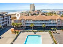 Charming three-story condo building with white balconies overlooking a pristine pool and picturesque ocean view at 27 Ocean Isle West Blvd., Ocean Isle Beach, NC 28469