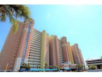 Low angle shows the colorful, multi-story building with multiple balconies and mature palm trees in a bright blue sky at 2801 S Ocean Blvd. # 1034, North Myrtle Beach, SC 29582