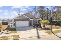 Charming one-story home with a brick facade, manicured landscaping, and a two-car garage on a sunny day at 2815 Eclipse Dr., Myrtle Beach, SC 29577