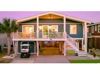 Charming raised beach house with a blue exterior, white railings, and a spacious ground-level entertainment area at 40 Fairmont St., Ocean Isle Beach, NC 28469