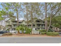 Charming multi-story condo complex nestled amongst trees with 'Spinnaker's Reach' sign at 404 72Nd Ave. N # 203, Myrtle Beach, SC 29572