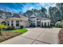 Charming brick home with a spacious driveway and well-manicured landscaping at 45 Dornoch Dr., Pawleys Island, SC 29585