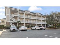 Three story condo building with white balconies, ample parking, and lush landscaping at 805 Crumpet Ct. # 1165, Myrtle Beach, SC 29579