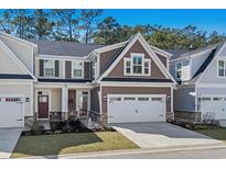Beautiful two-story townhome boasts manicured lawn, attached two-car garage and architectural shingles on gable end at 115 Galil Dr. # B, Myrtle Beach, SC 29579
