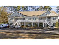 Two story condo building with front white railings and parking at 160 Lazy Willow Ln. # 204, Myrtle Beach, SC 29577