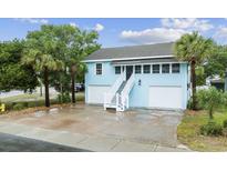 Charming light blue two-story home with dual garage, stairway entry, and mature palm trees at 214 2Nd Ave. S, North Myrtle Beach, SC 29582