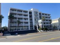 Multi-story condo building boasting multiple balconies with white railings and palm trees at 2708 S Ocean Blvd. S # 302, Myrtle Beach, SC 29577