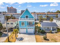 Charming coastal home with a light blue exterior, balconies, and a two-car garage at 309 20Th Ave. N, North Myrtle Beach, SC 29582