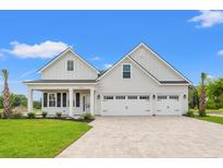 Charming white two-story home with three-car garage and patterned brick driveway at 368 Hayloft Circle, Conway, SC 29526