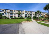 Well-maintained condo complex with manicured lawn, shrubbery, walkway, and mature palm trees at 405 21St Ave. S # 1-O, North Myrtle Beach, SC 29582