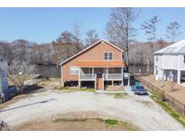 Inviting waterfront home with a metal roof, gravel driveway, and a charming covered porch at 5865 Creekside Dr., Myrtle Beach, SC 29588