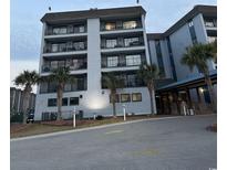Multi-story condo building showcasing a light blue facade, multiple balconies, and palm trees at 5905 S Kings Highway # B-455, Myrtle Beach, SC 29588