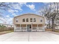 Charming two-story home with a spacious front porch and a large concrete driveway, inviting curb appeal at 613 Calhoun Dr., Murrells Inlet, SC 29576