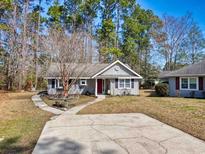 Charming single-story home with a well-manicured front yard and inviting red front door at 6634 Cinnamon Fern Ln., Myrtle Beach, SC 29588