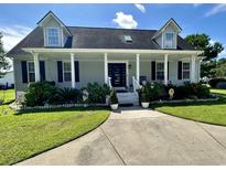 Charming home featuring a inviting front porch, beautiful landscaping, and a well-manicured lawn at 6636 Breezewood Blvd., Myrtle Beach, SC 29588