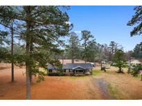 Cozy single-story home with a covered front porch and mature trees, offering a serene country setting at 1206 French Rd, Mullins, SC 29574