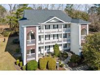 Exterior view of a three-story apartment building with brick accents and private balconies at 1282 River Oaks Dr. # 9F, Myrtle Beach, SC 29579