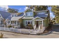 Charming green two-story home with white picket fence and manicured lawn adds curb appeal to the neighborhood at 136 Da Gullah Way # A, Pawleys Island, SC 29585