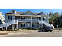 Inviting two-story condo featuring double balconies, gray siding and convenient parking at 1407 Gooseneck Place # 202, Murrells Inlet, SC 29576