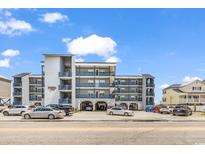 Condo building with a gray exterior, multiple balconies, parking beneath, and steps on either side at 200 N Waccamaw Dr. # 3F, Murrells Inlet, SC 29576