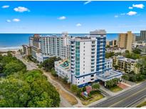 Stunning aerial view of oceanfront condo with palm trees, meticulous landscaping and a circular driveway at 215 77Th Ave. N # 413, Myrtle Beach, SC 29572